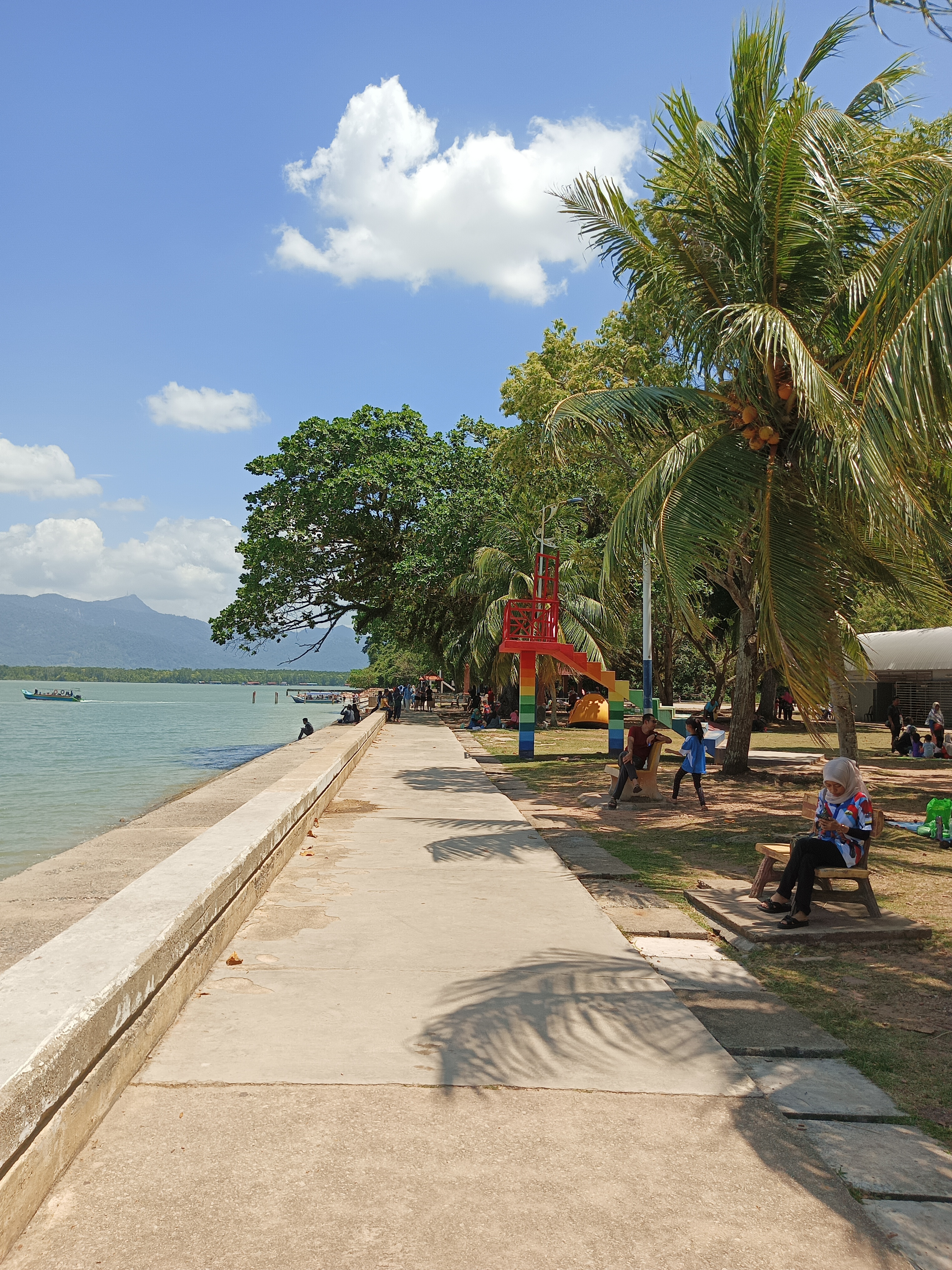 Cahaya senja menyinari pokok-pokok tepi Pantai Merdeka